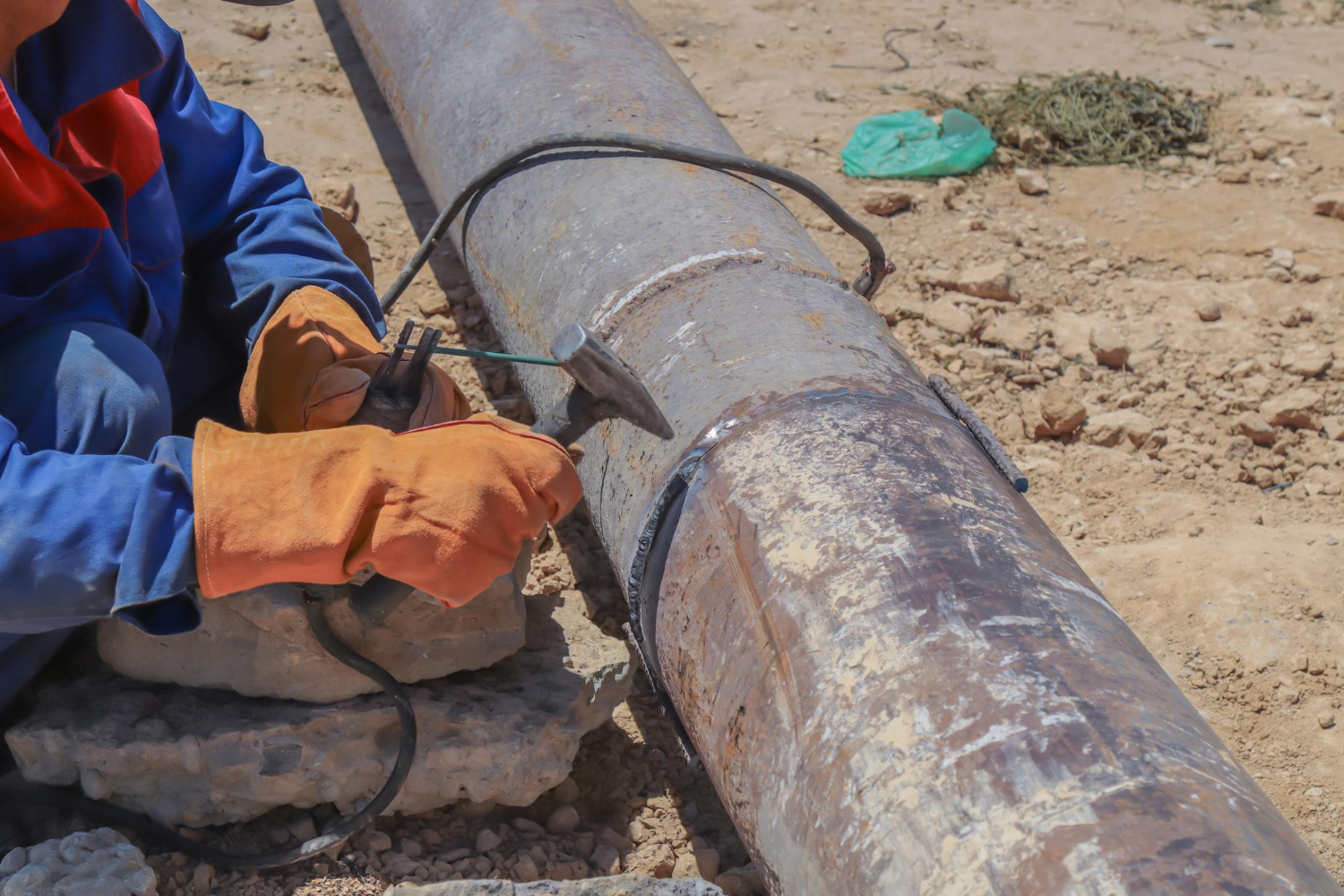 Person working in the field doing field service and repair for pipes